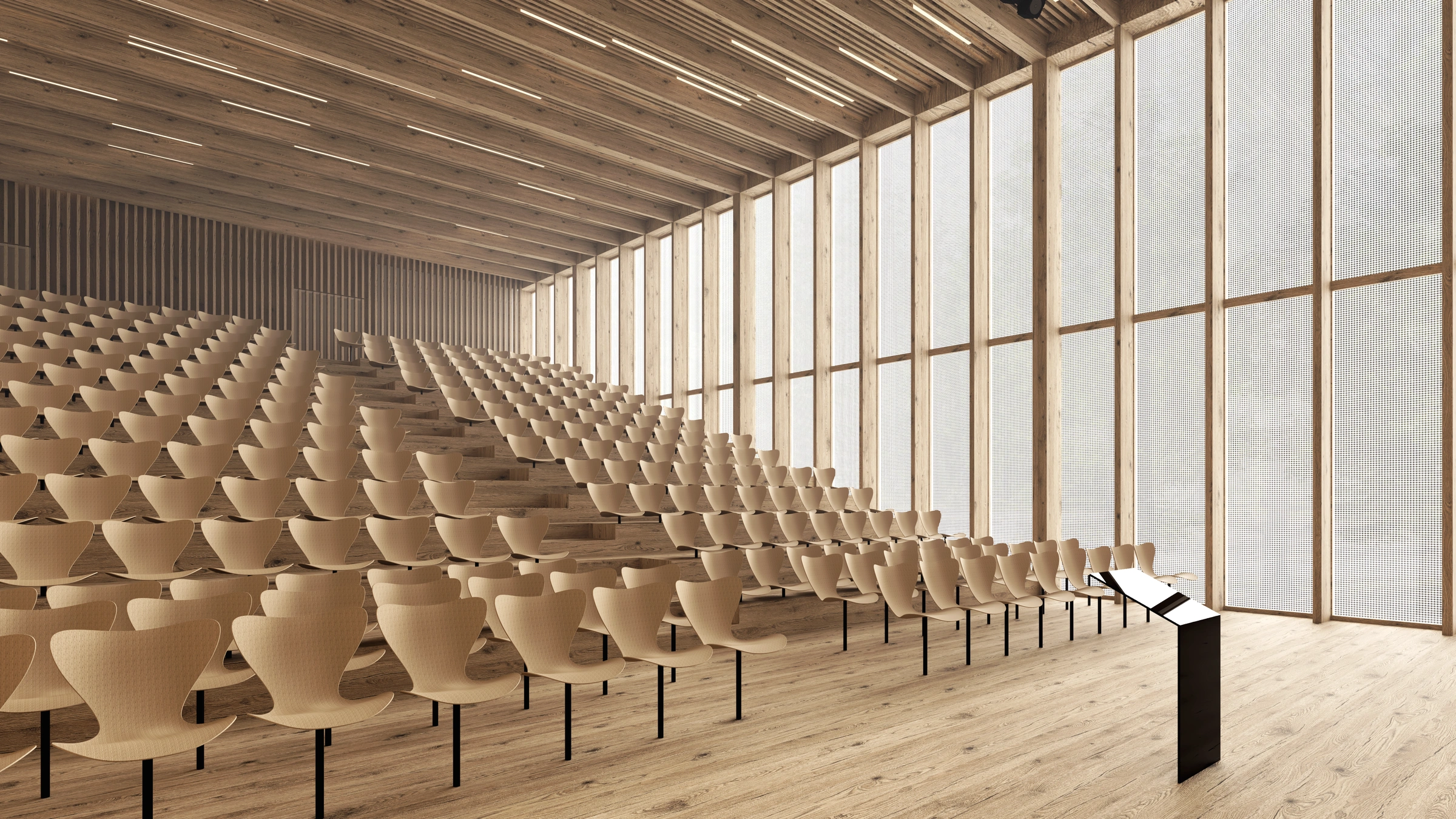 University auditorium with tiered seating, timber structure and tall side windows.